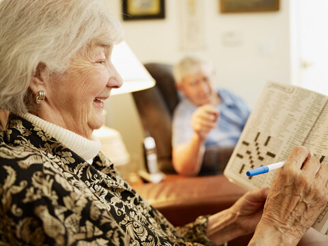 Elderly Couple in Retirement Home, Woman Working on Crossword Puzzle