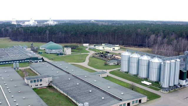 Aerial view of pig farm with grain drying towers and biogas plant. Modern complex for drying, cleaning and storage a grain. High quality 4k ProRes footage