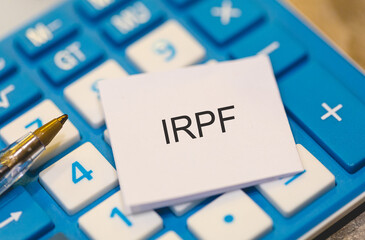 As iniciais IRPF referente ao Imposto de Renda da Pessoa Física escritas em um pedaço de papel em...
