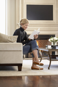 Woman Reading Book in Living Room