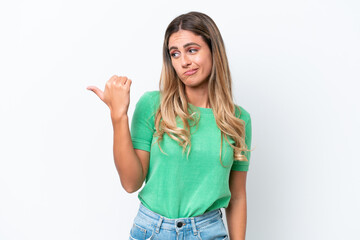 Young Uruguayan woman isolated on white background unhappy and pointing to the side