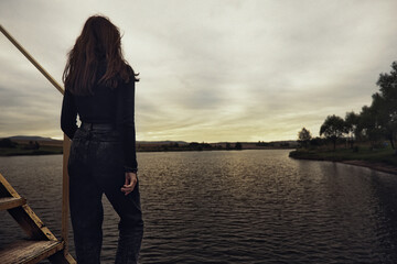 a teenage girl stands alone on the pier at the pier trying to cope with anger and find strength in...