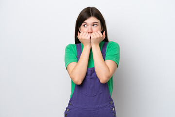 Young Russian woman isolated on blue background nervous and scared putting hands to mouth