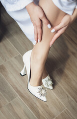 legs of a woman.  the bride puts on the wedding shoes on her tender feet