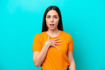 Young caucasian woman isolated on blue background surprised and shocked while looking right