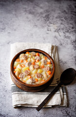 Fototapeta na wymiar Potato carrot white bean soup with meat sausages in a bowl