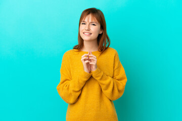 Redhead girl isolated on blue background scheming something