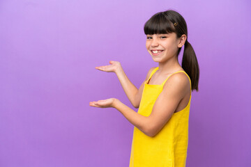 Little caucasian kid isolated on purple background extending hands to the side for inviting to come