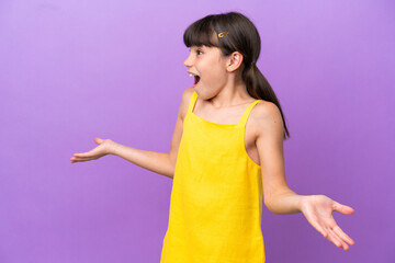 Little caucasian kid isolated on purple background with surprise expression while looking side
