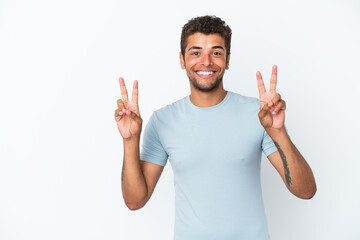 Young handsome Brazilian man isolated on white background showing victory sign with both hands