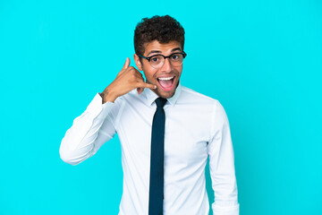 Young business Brazilian man isolated on blue background making phone gesture. Call me back sign