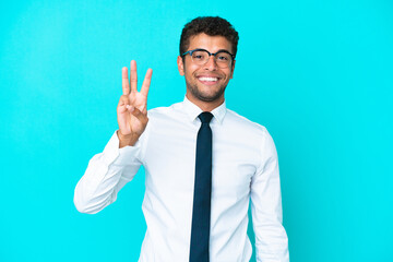 Young business Brazilian man isolated on blue background happy and counting three with fingers