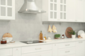 Fototapeta na wymiar White cosy kitchen with furniture, blurred view. Interior design