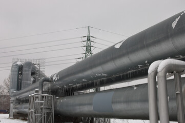 pipeline and power line in the city in winter against the gray sky.