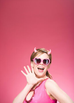 Portrait of Woman Wearing Devil Horns and Heart Shaped Eyeglasses