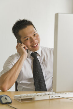 Businessman Talking on Mobile Phone in Office