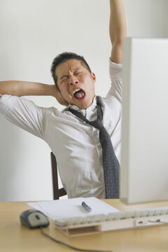 Businessman Yawning at Desk