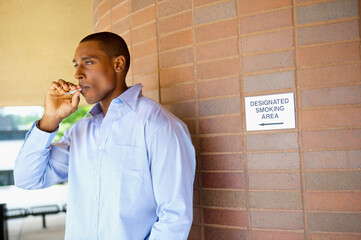 Man Smoking a Cigarette in Designated Area