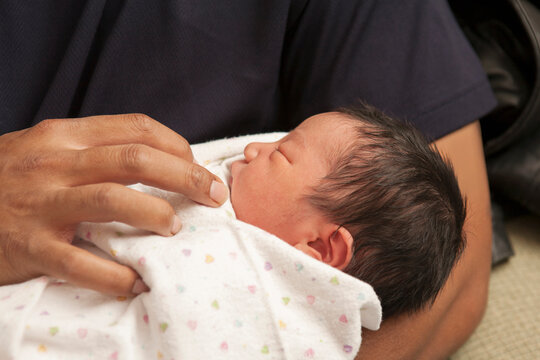 Close-up of father holding newborn baby girl, USA