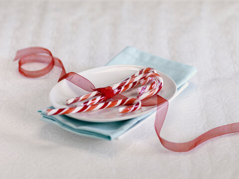 Candy Canes Tied with Red Ribbon on Plate
