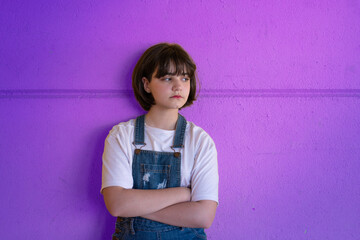 Menina de cabelo curto, fazendo pose em parede roxa. Estilo de vida e moda.