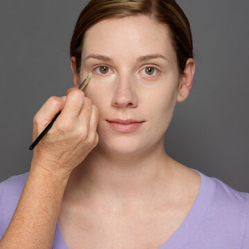 Close-up of Woman having Eye Make-up Applied, Studio Shot