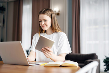A smart woman student freelancer online training education, at home workplace uses a laptop writes a message to the mail.