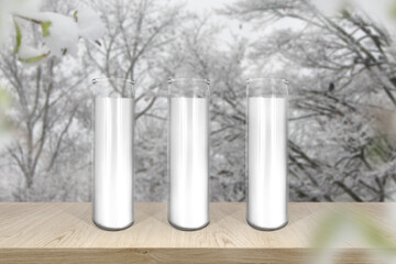 Glass white wax candles mock up on background of winter forest landscape