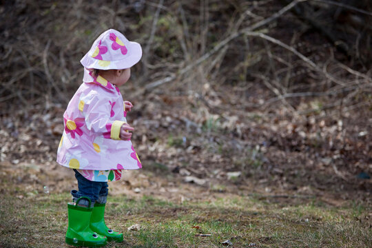 Little Girl in the Park Wearing Raincoat, Hat, and Boots, Bethesda, Maryland, USA