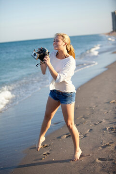 Young Woman Taking Pictures at Beach with Camera, Palm Beach Gardens, Palm Beach, Florida, USA
