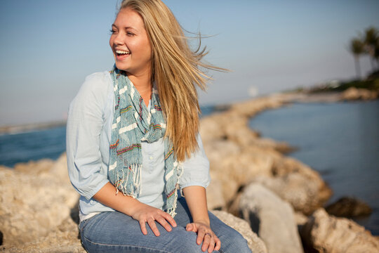 Young Woman Sitting on Rocks at Beach, Jupiter, Palm Beach County, Florida, USA