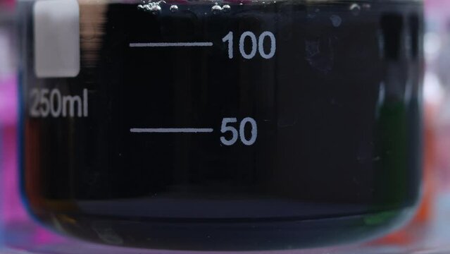 The chemical reaction of the formation of a water-insoluble inorganic compound - black iron sulfide in a beaker.