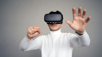 A man uses virtual reality glasses, plays a video game.