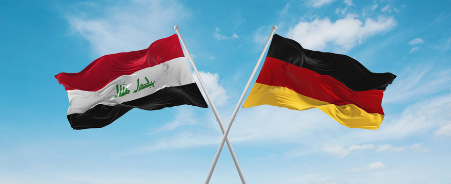 Two Crossed Flags Federal Republic Of Germany And Iraq Waving In Wind At Cloudy Sky. Concept Of Relationship, Dialog, Travelling Between Two Countries