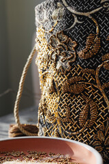 bag of precious stones sits on table, soft selective focus. bead embroidery, hobby design and sewing. handmade, gold glass on clutch