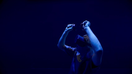 Obraz na płótnie Canvas Teenager playing virtual reality in neon light closeup. Cyber gamer enjoy online