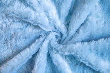 Fluffy fabric twisted in the center, soft fluff on the carpet, woolen bedspread.
