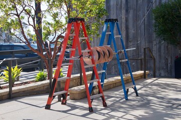 Two construction ladders holding spools of wire
