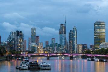 Fototapeta premium Beautiful view of London city landscape from Thames waterfront at night, handheld shot. Rapid growth and urban development concept.