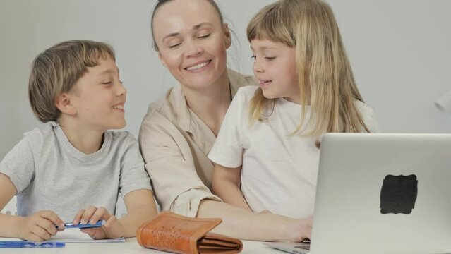 Mother and two children are purchasing something online.