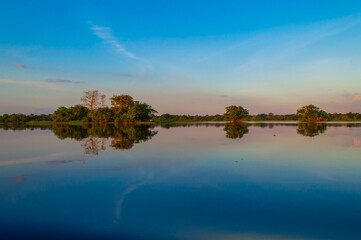 Obraz premium Mirror reflections on the water of Rio Amazonas in Brazil at sunset during a canoe excursion in the middle of the rain forest