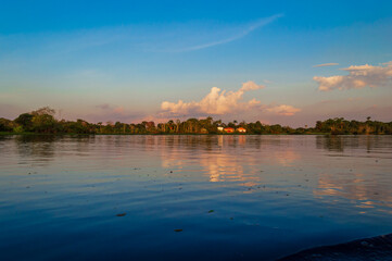 Mirror reflections on the water of Rio Amazonas in Brazil at sunset during a canoe excursion in the middle of the rain forest