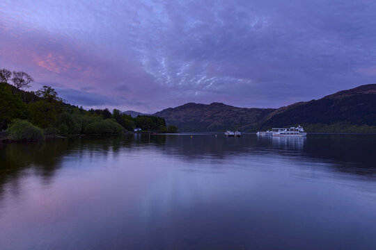 Cruise ships on lake at dawn at Loch Lomond in Scotland, United Kingdom