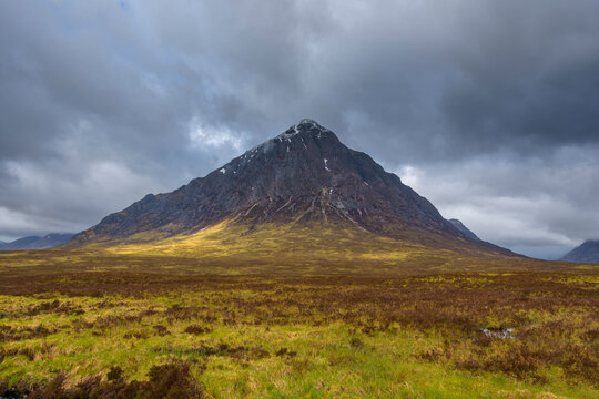 Mountain range Buachaille Etive Mor with dark cloudy sky at Glen Coe in Scotland, United Kingdom