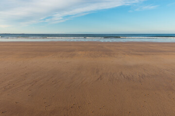 Sandy beach and North Sea at low tide in the morning at Bamburgh in Northumberland, England, United Kingdom