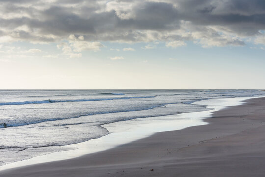 Surf of the North Sea along the beach at Bamburgh in morning light in Northumberland, England, United Kingdom