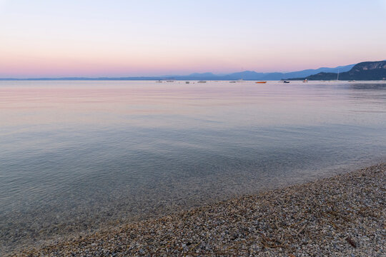 Beach and lakeshore at dawn on Lake Garda (Lago di Garda) at Bardolino in Veneto, Italy