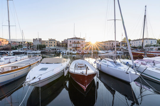 Row of boats in the harbor marina at sunrise on Lake Garda (Lago di Garda) in Bardolino in Veneto, Italy