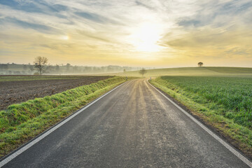 Morning sun shining over a country road in Freiensteinau in the Vogelsberg District in Hesse, Germany