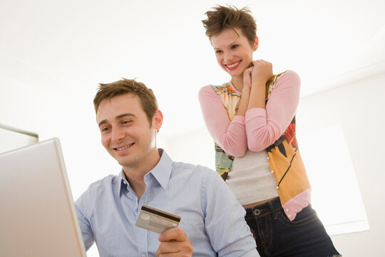 Young Couple with Credit Card and using Computer
